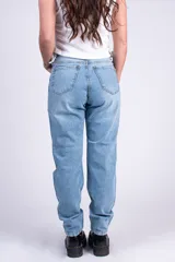 Jean mom fit de tiro alto color celeste, con roturas y desgastes en las piernas, bolsillos delanteros y traseros.