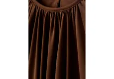 Blusa de manga larga color marrón oscuro con escote redondo y frunces frontales.