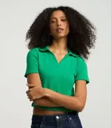 Blusa de manga corta confeccionada en tejido rib de algodón con elastano. Presenta cuello polo con escote en V y diseño ajustado al cuerpo.