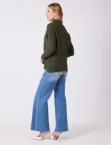 Buzo de tejido acanalado color blanco, con cuello alto y diseño de patrón en V en el frente. Presenta un corte holgado con mangas integradas sin costura de sisa.