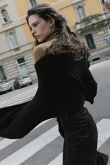 Bufanda de punto lisa en color negro, confeccionada en una mezcla de tejidos con un 5% de lana.