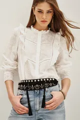 Camisa de algodón en color violeta oscuro, con diseño de volados frontales, mangas largas con puños ajustados y textura sutil en la tela.