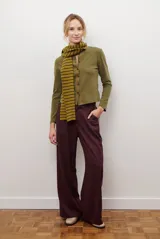 Cardigan de algodón color verde oliva, con cuello redondo, cierre frontal de botones y mangas largas. Presenta un corte recto y entallado.