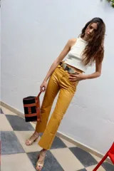 Pantalón de cuero celeste de tiro alto y silueta recta, con bolsillos y cierre frontal.