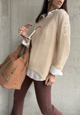 Buzo color beige de hilo con mangas largas y detalle de calado en los hombros.