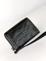 Mini billetera de cuero con textura efecto cocodrilo y cierre perimetral. Presenta un parche central con el logo de la marca grabado.