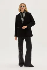 Blazer negro de corte clásico con cierre frontal de botones y detalle de bordado artístico en la espalda que representa un caballo y motivos florales.