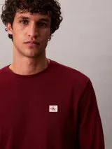 Remera de manga larga Calvin Klein en tejido térmico de punto con textura tipo nido de abeja, color bordó, de corte regular con cuello redondo y puños acanalados. Cuenta con un pequeño parche con el logo de la marca en el pecho.