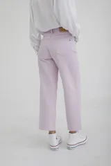 Pantalón de jean color amarillo pastel, de corte recto y tiro medio, con diseño de cinco bolsillos y cierre frontal con botón y cremallera.