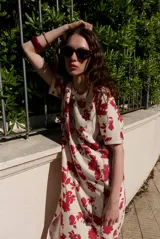 Vestido midi de manga corta, con diseño holgado, cuello redondo y estampado abstracto con detalles florales en tonos marrones y violetas.