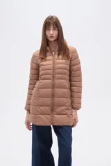 Campera larga acolchada color negro, con cierre frontal y cuello alto. Presenta costuras horizontales que crean un efecto puffer.