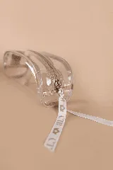 Necessaire transparente de PVC con cierre y bordes en color beige, ideal para guardar artículos pequeños de maquillaje o cuidado personal.