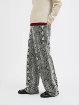 Pantalón tiro alto de pierna ancha con estampado animal print de serpiente en tonos beige, blanco y negro.