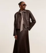 Falda midi marrón de cuero sintético con cintura sastre y textura plisada.