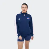 Buzo deportivo azul marino con medio cierre frontal, cuello alto y bandas rosadas en las mangas. Presenta el logo de Umbro y el escudo del Club Nacional de Football bordados en el pecho, además de un bolsillo tipo canguro.