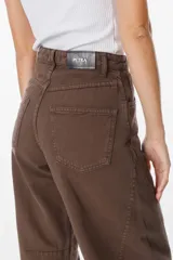 Jean de corte recto y tiro alto en color marrón, con bolsillos traseros clásicos y etiqueta de cuero sintético con logo de la marca en la cintura.