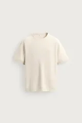 Camiseta regular fit de punto tejido en hilatura de algodón, color beige, con cuello redondo y manga corta, con acabados en rib.