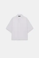 Camisa de cuello solapa y manga corta acabada en vuelta, con diseño fluido y cierre frontal de botones ocultos.