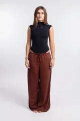 Body negro de manga corta y cuello alto, ajustado al cuerpo, con un recorte ovalado en el pecho que presenta un logo en relieve.