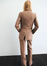 Pantalón Natalie de tiro medio y diseño recto, confeccionado en mezcla de poliéster y lana. Cuenta con bolsillos laterales, bolsillos posteriores de ribete y cierre frontal oculto con botón, gancho y cremallera.
