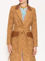 Trench marrón claro con broderie y detalles en cuero marrón, con hombreras, bolsillos plaqué con tapa de cuero y lazo para ajustar en cintura.