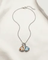 Collar de cadena fina de acero con dos dijes colgantes en forma de triángulo, uno con circonia color naranja y otro con circonia color celeste.