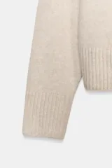 Jersey de punto color vino tinto, de cuello redondo y manga larga, con acabado acanalado (rib) en puños, cuello y bajo.