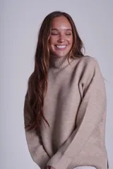 Sweater tejido de punto color beige, con cuello alto y trama lineal.