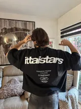Remera negra de algodón con estampado blanco en la espalda con el logo de la marca y la frase "European Tour by Ittai Stars Company".
