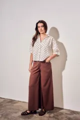 Blusa de lino y viscosa color blanco con estampado de lunares marrones, de manga corta y cuello camisero con cierre frontal de botones.