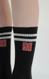 Medias 3/4 de algodón color negro, con diseño deportivo que incluye dos franjas blancas horizontales en la parte superior, el número 90 bordado en rojo y blanco, y el logo de la marca Luxo en la zona del talón.