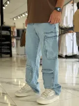 Pantalón de jean estilo cargo, color azul, de corte ancho y holgado, con múltiples bolsillos laterales en muslos y pantorrillas.