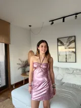 Vestido corto de satén color verde azulado (teal) con escote strapless y detalle de frunce central con argolla. Presenta tirantes finos que se atan al cuello y aberturas laterales en la cintura.