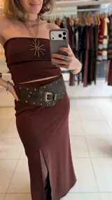 Falda midi color marrón, de tiro alto y confeccionada en lycra elastizada, con tajo frontal pronunciado.