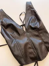 Top sin mangas de ecocuero con textura efecto reptil, escote en V profundo y corte entallado.