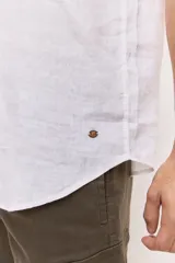Camisa de manga corta en color blanco, con cuello clásico y cierre frontal de botones al tono. Presenta un diseño versátil de corte regular y textura liviana, ideal para looks frescos.