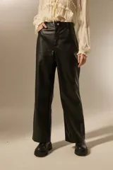 Pantalon de corte recto confeccionado en eco-cuero negro, con tiro medio y costuras horizontales a la altura de la rodilla.