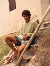 Sweater de algodón negro con diseño de tejido calado, cuello redondo y manga larga.
