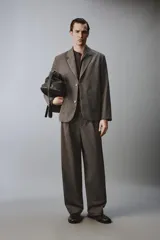 Blazer de corte relajado en color marrón oscuro, con cuello de solapas de muesca, cierre frontal de dos botones y bolsillos de plastrón en la parte delantera.