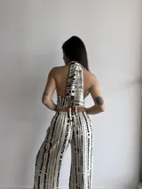 Pantalón de pierna ancha con estampado de rayas verticales negras sobre fondo crudo, confeccionado en tela slab con cintura elástica.