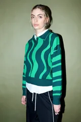 Sweater de tejido de punto con cuello polo y tapeta de botones, presentando un diseño de rayas onduladas anchas en dos tonos de verde.