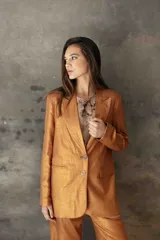 Blazer sastrero de corte recto y fit relajado, confeccionado en lino con acabado metalizado lurex. Presenta hombreras, solapas clásicas, cierre frontal con dos botones de nácar y bolsillos laterales con solapa.