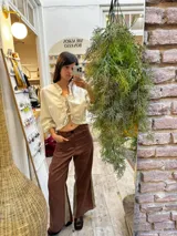 Pantalon sastrero de lino color marrón con paneles laterales en contraste beige, diseño de tiro alto y corte recto. Presenta un bordado de caballo en el bolsillo frontal.