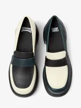 Mocasín de cuero color blanco con detalle de antifaz en negro y azul. Tiene suela track color negro y taco cuadrado.