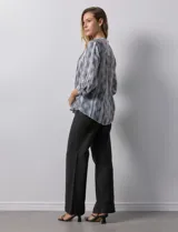 Blusa de gasa estampada multicolor, marca Ruby Rd. Tiene cuello a la base, escote en V, abertura central con botones y plisados en la parte delantera. Las mangas son 3/4 y tienen un largo regulable con presilla y botón.