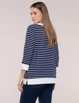 Buzo liviano de estilo deportivo-marinero y silueta semi holgada, confeccionado en tejido acanalado con diseño a rayas horizontales y verticales en azul marino y blanco. Cuenta con escote redondo amplio, cordón ajustable, bolsillo frontal tipo canguro, mangas tres cuartos con puños anchos y aberturas laterales en el ruedo.