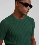 Remera masculina de algodón con textura acanalada y efecto punto. Presenta un diseño de corte regular, cuello redondo y manga corta.