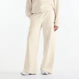 Pantalón de jogging New Balance color beige melange, de corte holgado y pierna ancha. Cuenta con cintura elástica con cordón de ajuste y un pequeño bordado con logo en el muslo izquierdo.