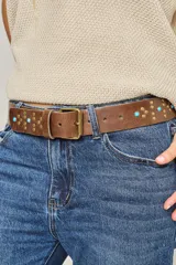 Cinturón marrón de cuero vacuno con hebilla metálica y apliques de tachas y turquesas.