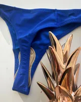 Parte inferior de bikini color azul eléctrico, estilo colaless con lazos ajustables a los costados.